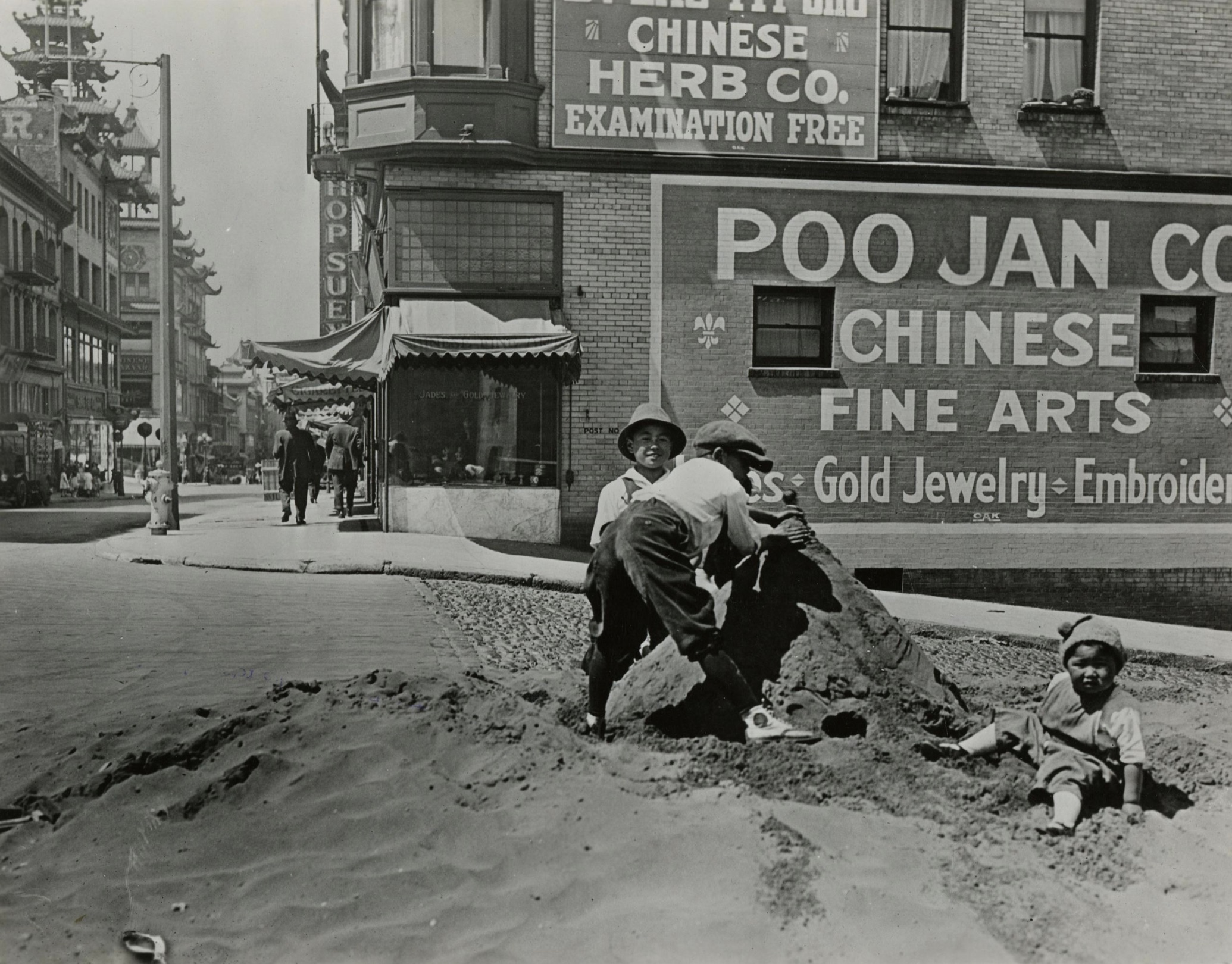 Chinese-American children playing with a pile of sand in San Francisco's Chinatown. Photo taken sometime after 1910